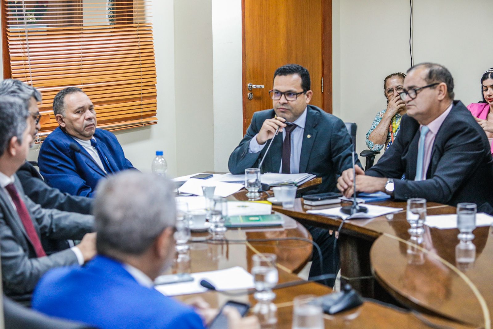 pessoas reunidas ao redor de uma mesa com papéis